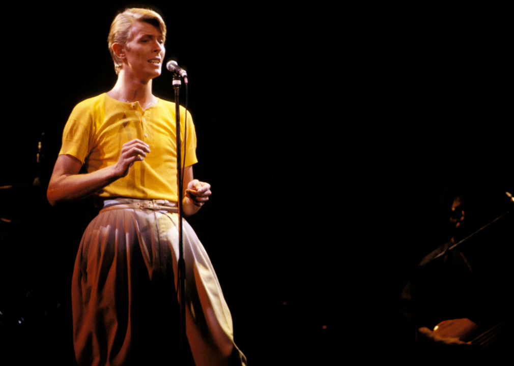 Bowie on stage speaks into a mic.