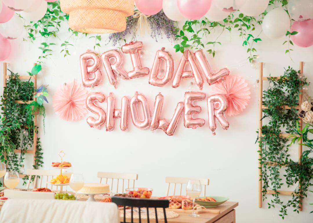 A room decorated with balloons and ribbons for a bridal shower.