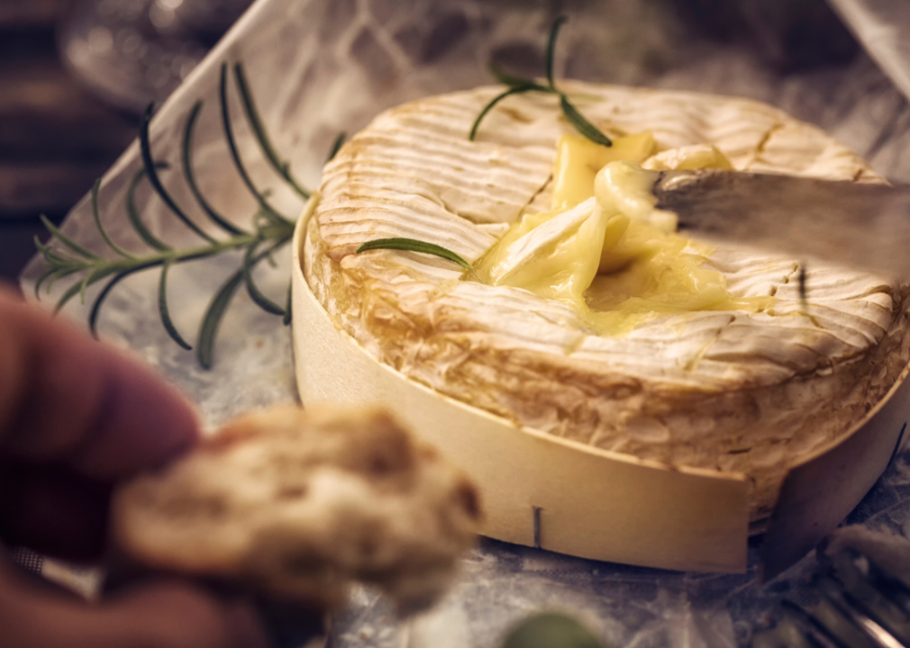 Baked Camembert cheese being sliced.