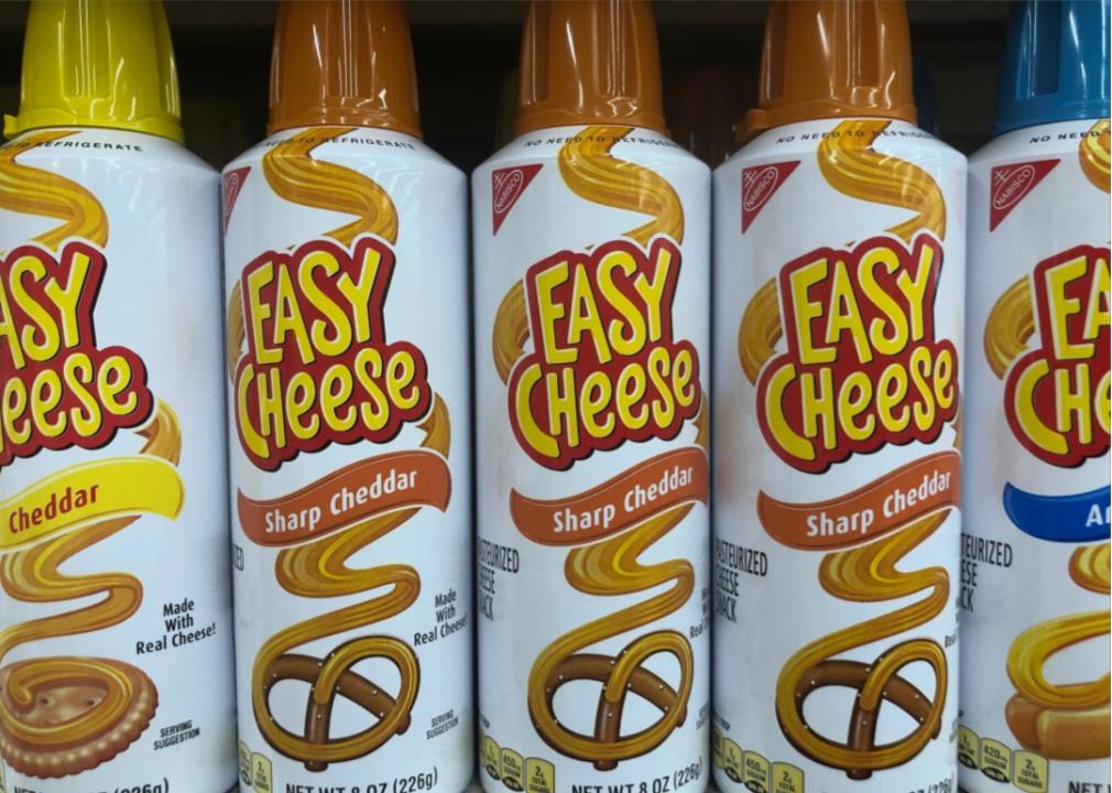 Close up of cans of "easy cheese" in various flavors. 