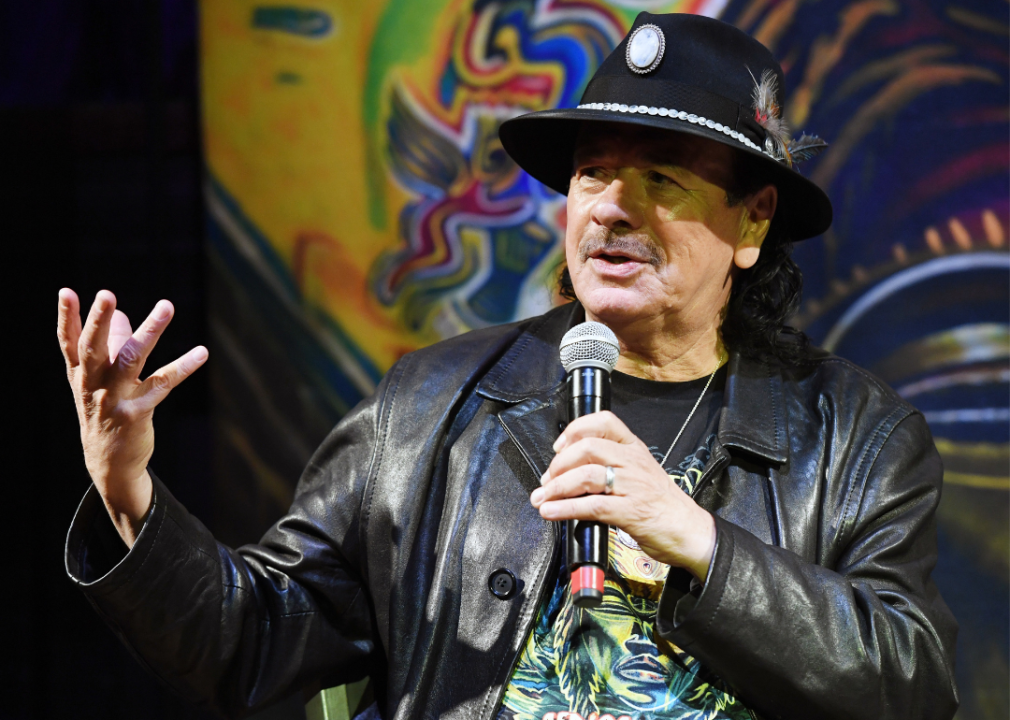 Carlos Santana speaks into a mic during a listening event for his album Africa Speaks.