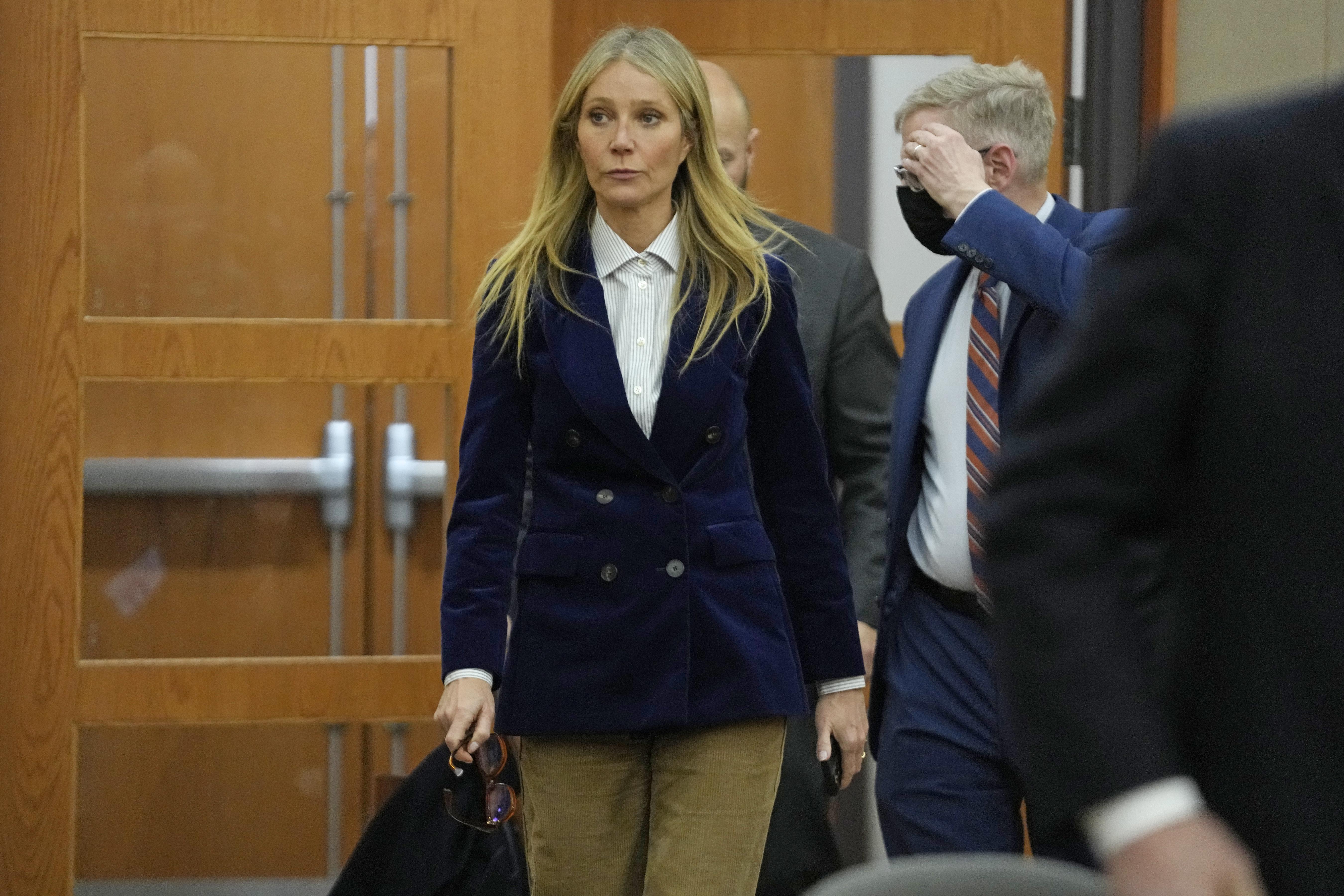 Gwyneth Paltrow entering a courtroom in a blue velvet blazer.