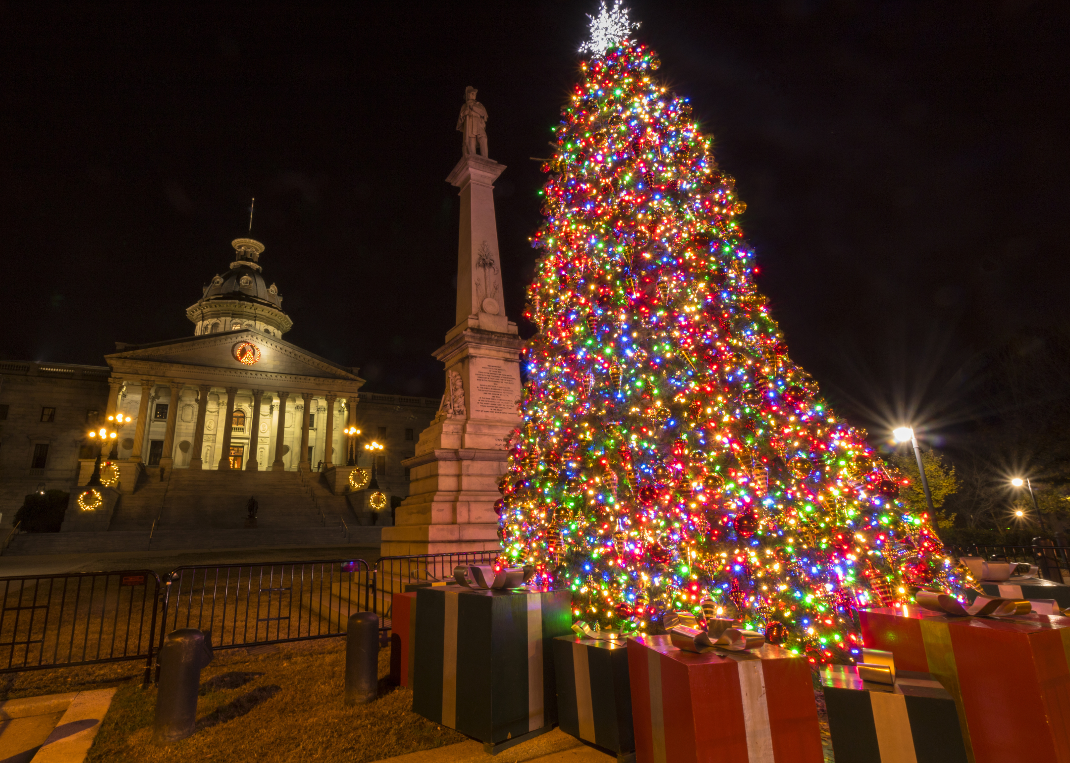 A Christmas tree at night in front of the capitol building.