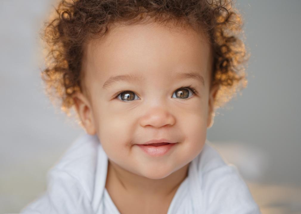 African American boy with curly hair smiling.