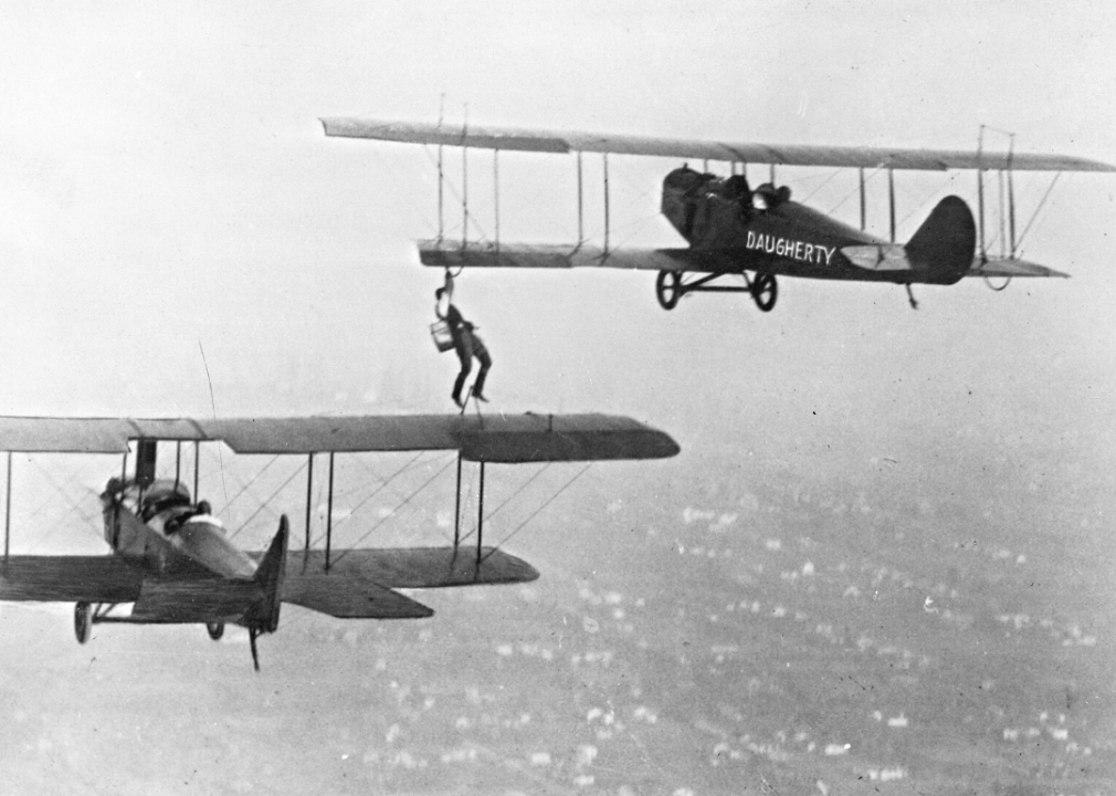 A daredevil climbs between two airplanes in flight