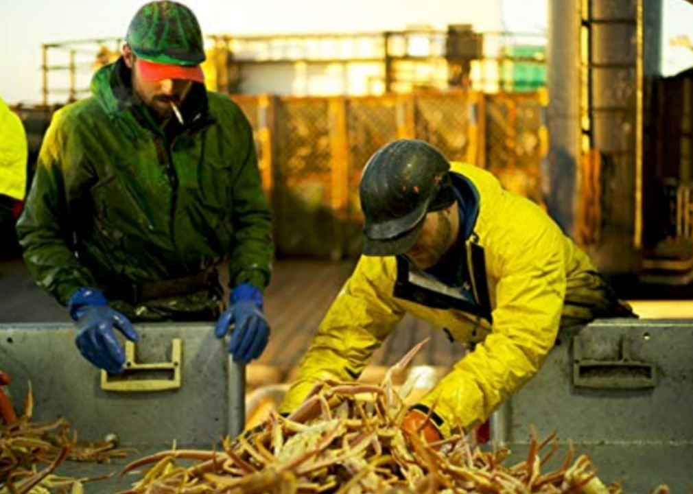 Fishermen sort through a pile of crabs