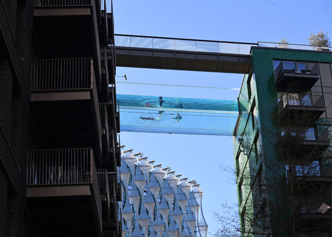 A clear, acrylic swimming pool suspended between two apartment blocks at the Embassy Gardens in London.