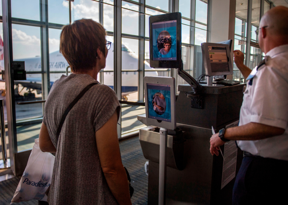 A woman using facial recognition verification at an airport.