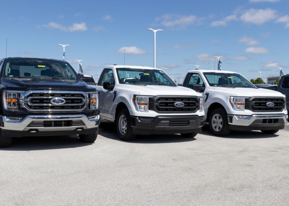 Three 2021 Ford F-150s on display at a dealership.