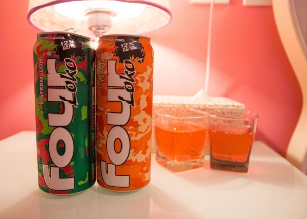 Two cans of Four Loko set against a pink backdrop.