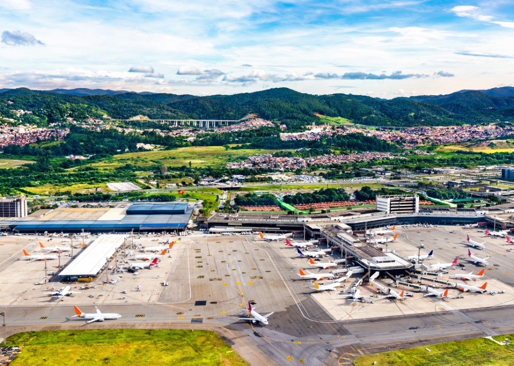Aerial view of an airport with green mountains in the background.