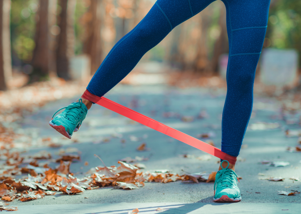 A person outside in fall with resistance bands on their legs.