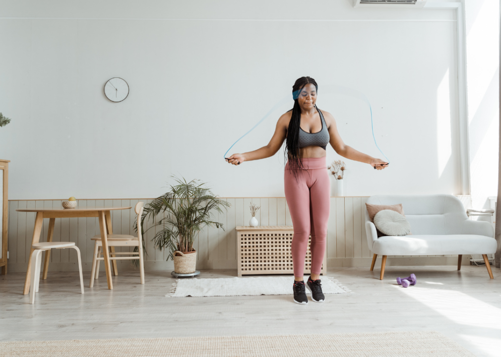 A woman jumping rope in her living room.