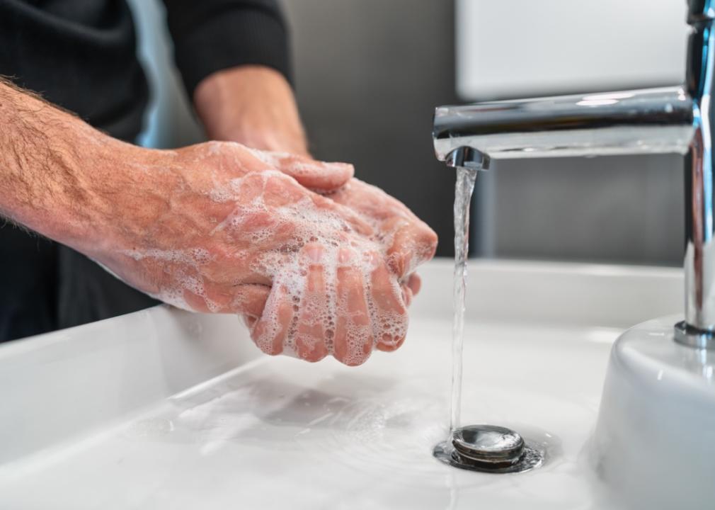 A man's hands are washed thoroughly with soap and water.