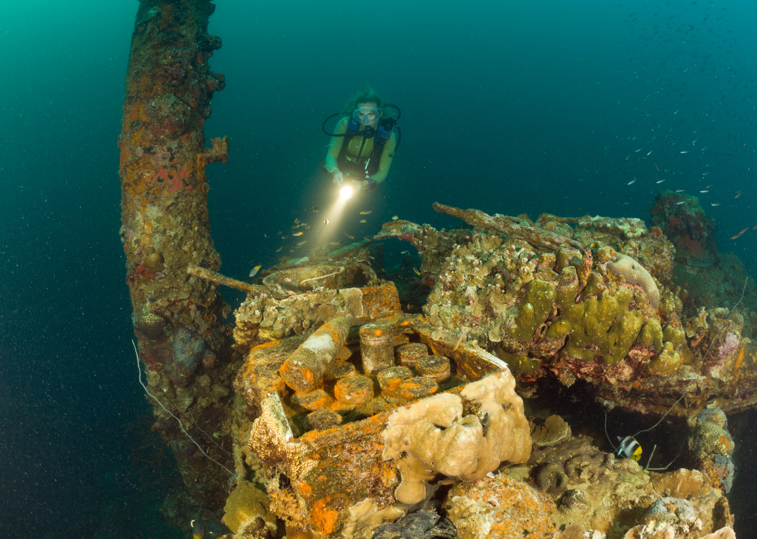 A diver exploring the sunken wreckage of a Japanese warship.