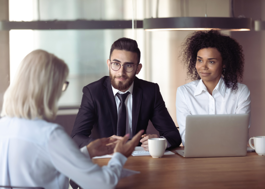 Two young HR professionals interview a mature woman.