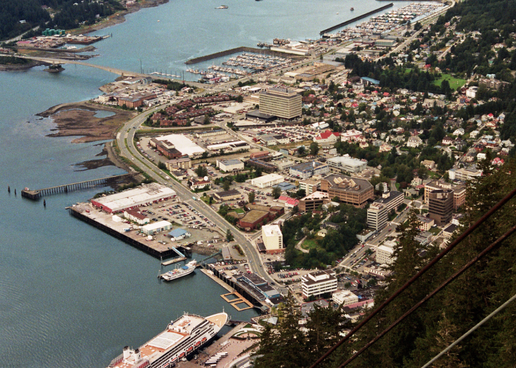 An aerial view of the city of Juneau in Alaska near a body of water. The city is located on a peninsula.