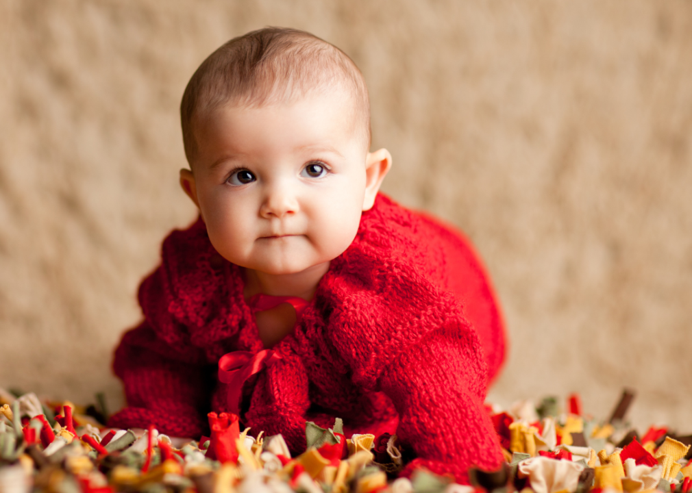 A baby girl in a red sweater.