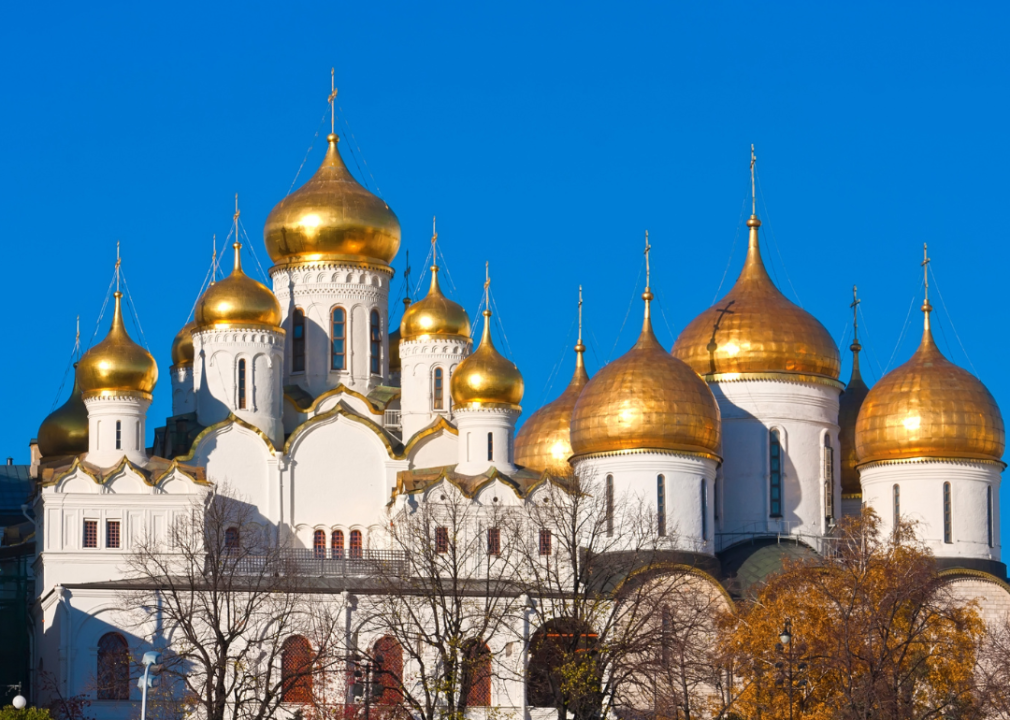 Golden onion domes on top of white cathedral.