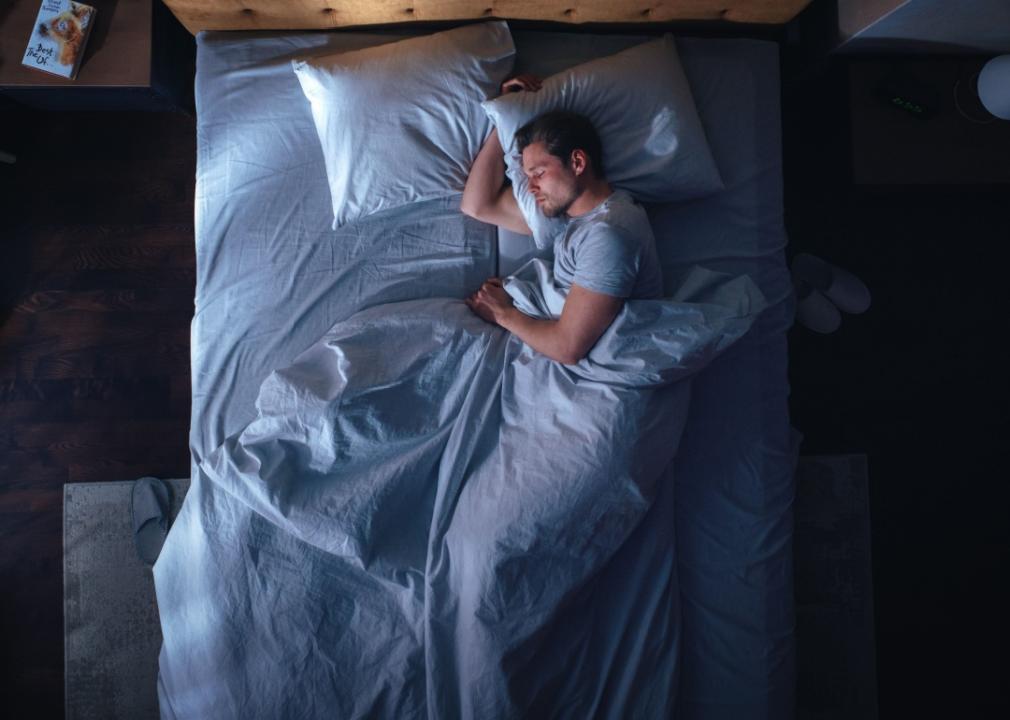 A young man sleeping in bed.