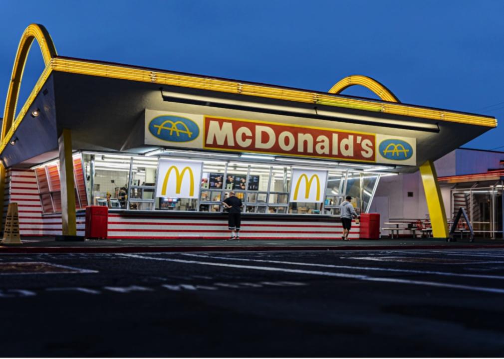 McDonald's restaurant featuring large yellow arches that extend above the roof and flank both sides of the building. 