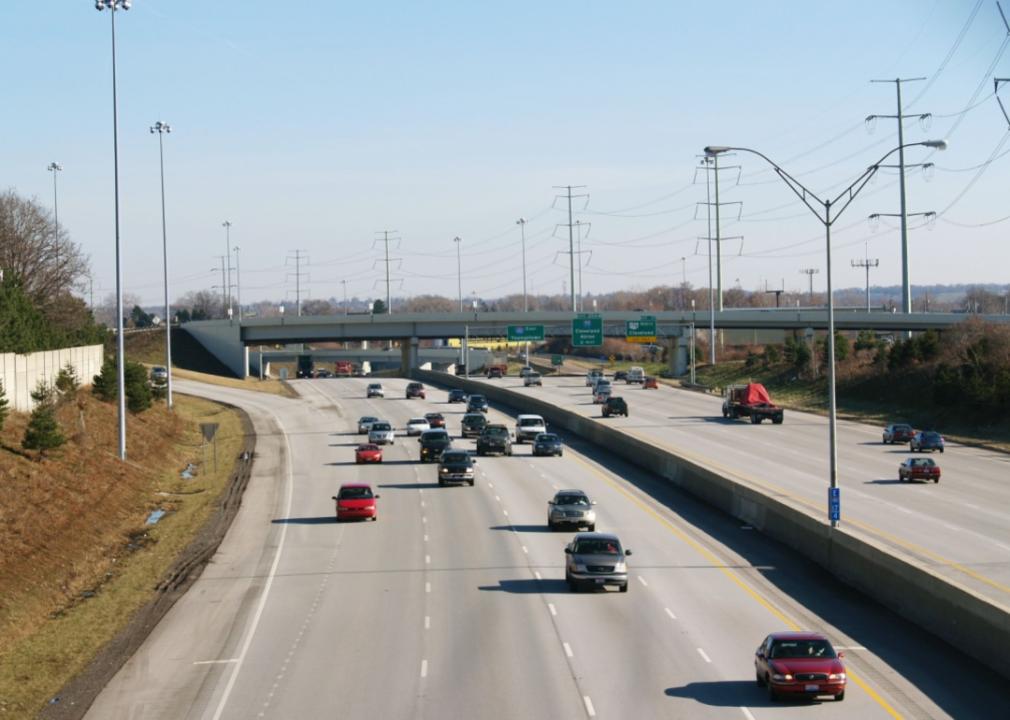 Freeway traffic going in both directions with a concrete barrier in the center dividing both sides of the highway. 