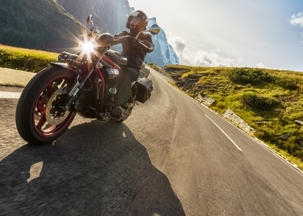 A person riding a motorcycle on a scenic mountain highway.