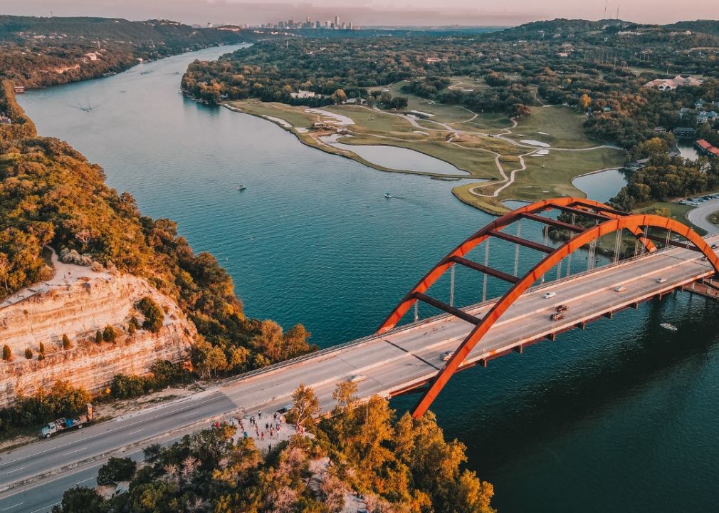 An aerial view of a bridge with the Austin skyline in the distance.