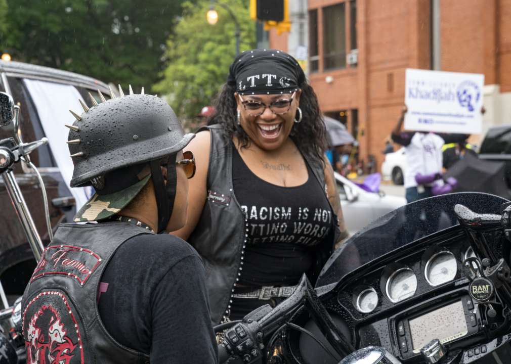 Two people with motorcycles talk at a Juneteenth parade in Atlanta, GA.