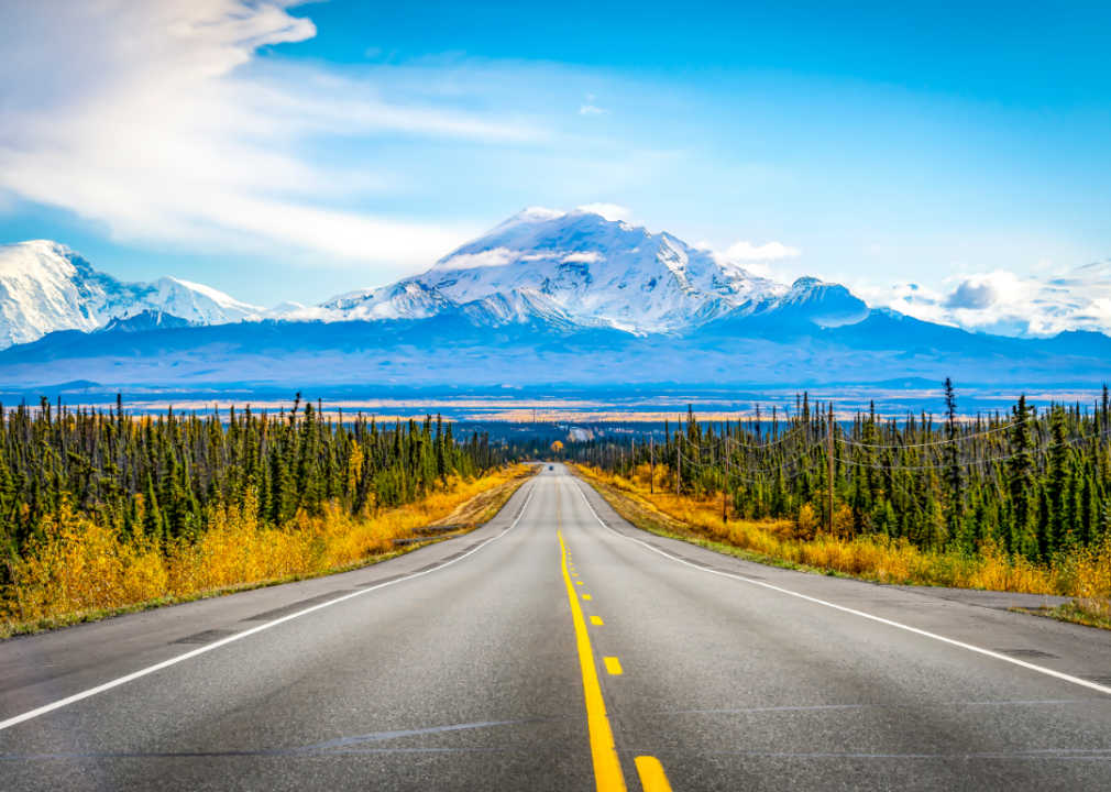 A highway leading to snow-capped mountains.