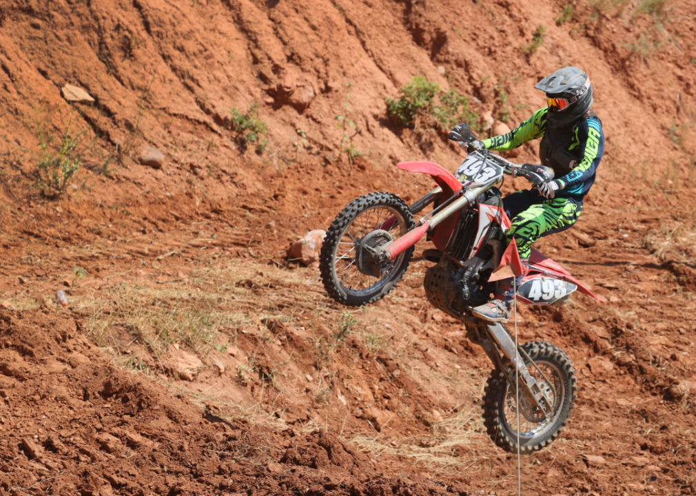 A motorcyclist competing in a competition in rugged terrain.