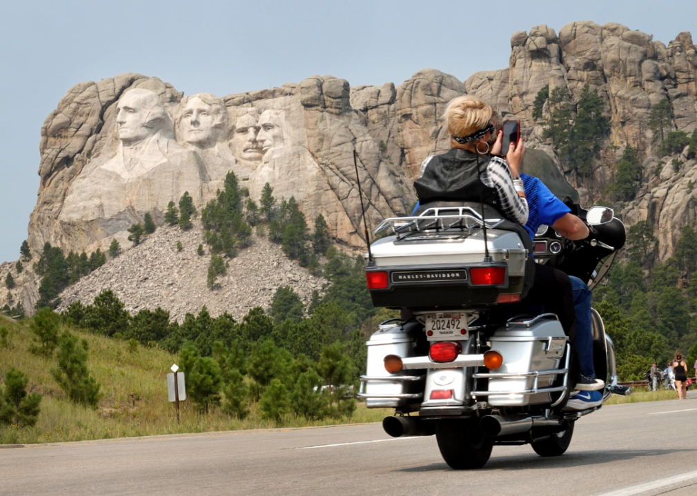 A motorcyclist rides along the road to Mt. Rushmore.