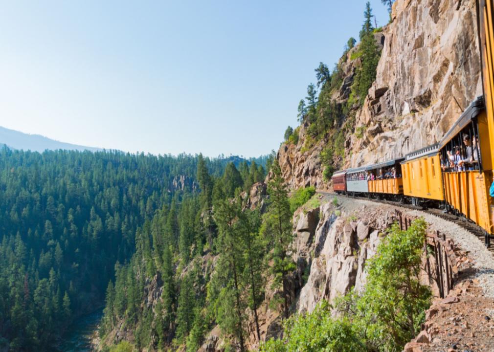 A train of tourists running along a cliff.
