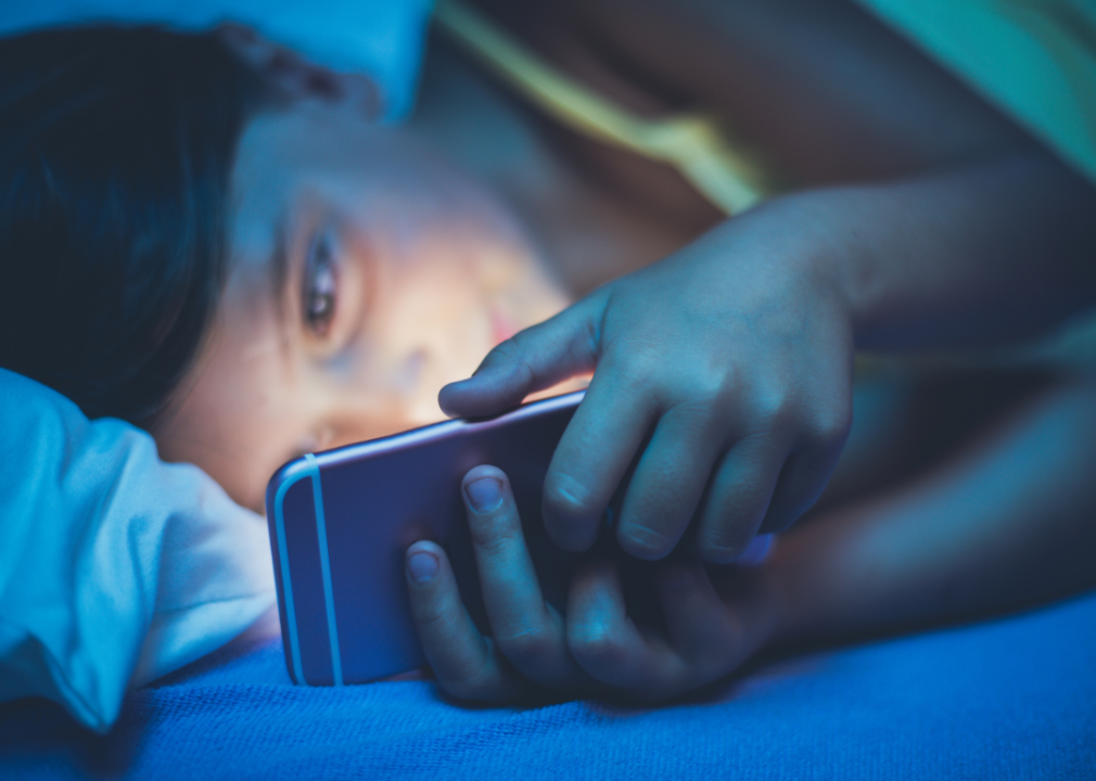 A person looking at a smartphone in bed.