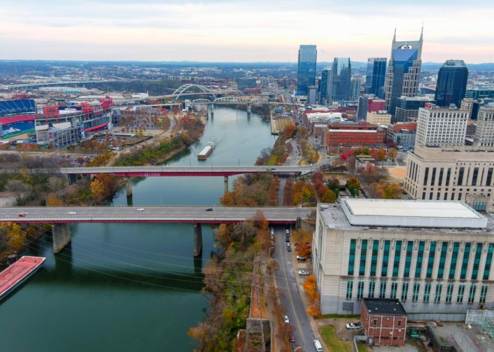 An aerial view of city with river flowing through the city. Several bridges cross the river. 