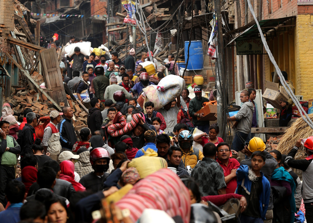 People carry belongings from their damaged or completely destroyed homes in Kathmandu, Nepal.