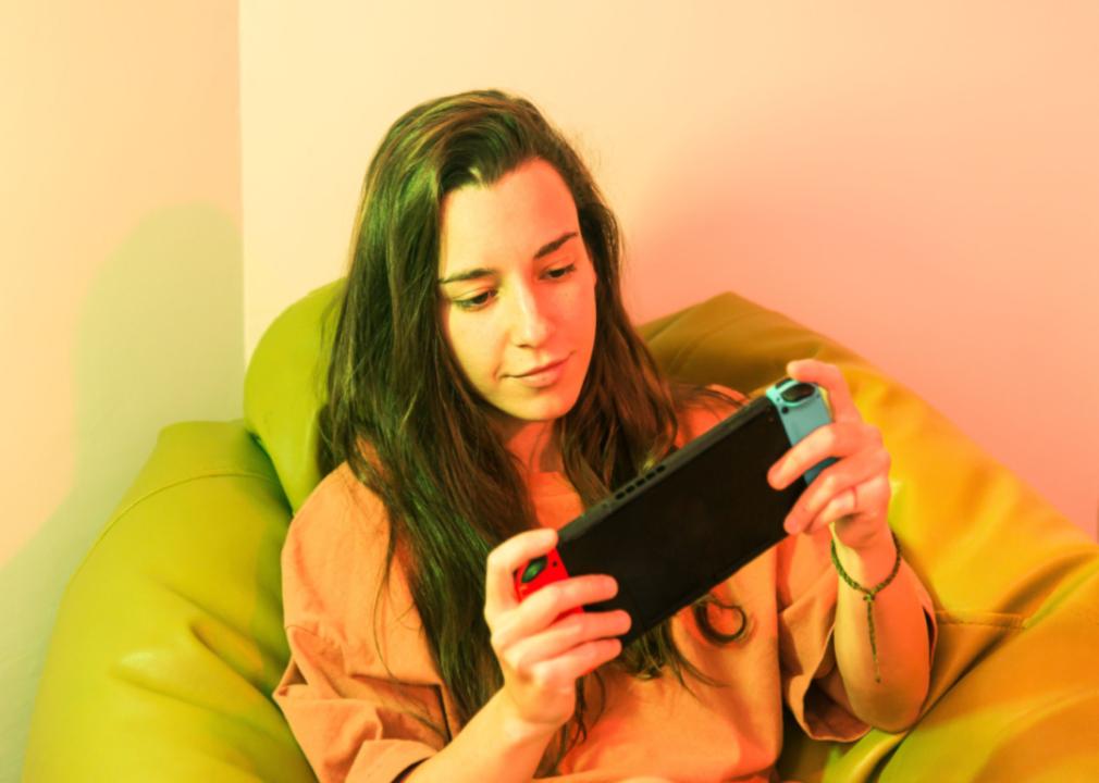 A girl in a beanbag chair playing Nintendo.