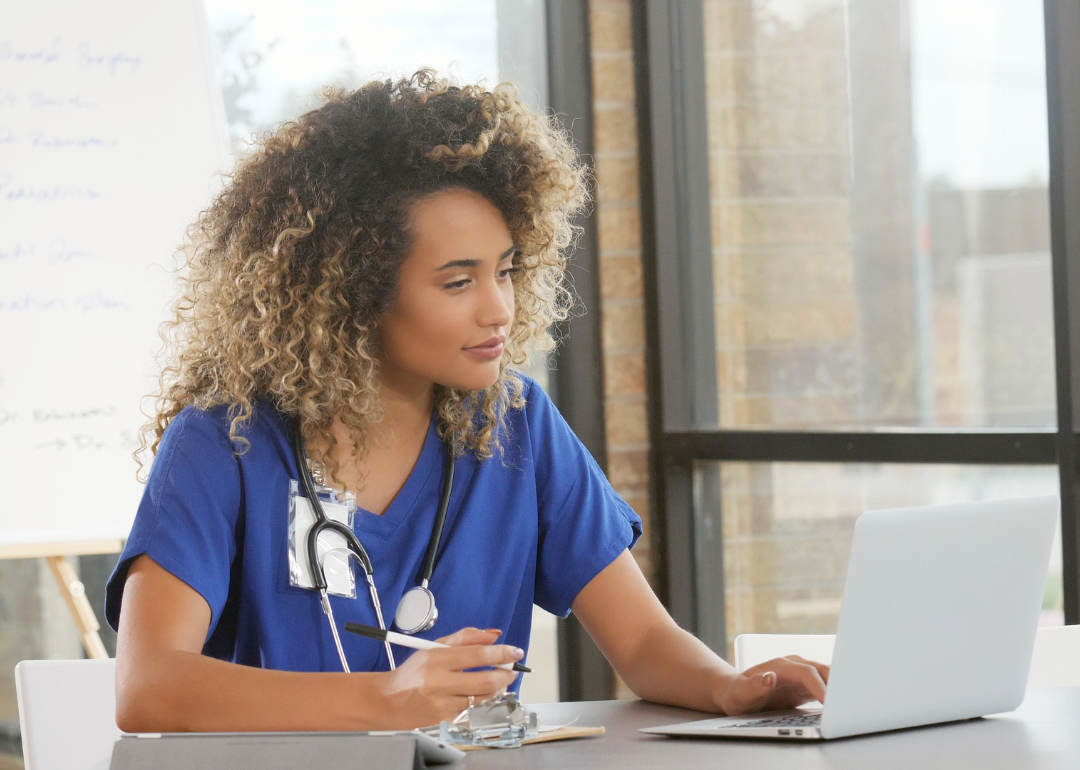 A nurse working at a laptop.