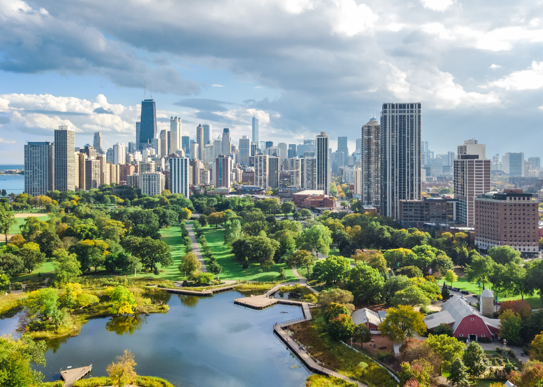 An aerial view of green parks and trees with the Chicago skyline in the background.