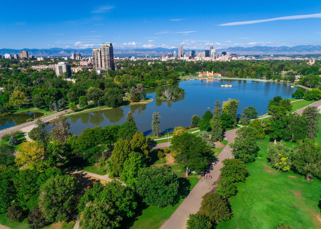 A large park surrounding water with Denver in the background.