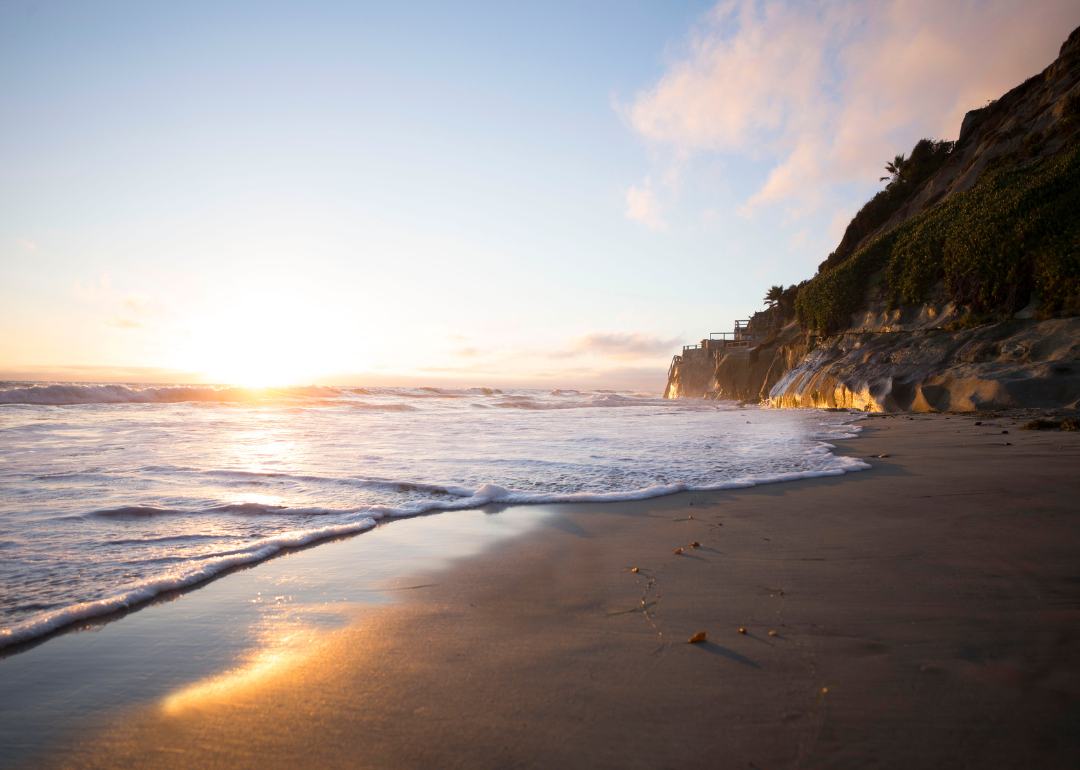 A cliff on the beach at sunset.