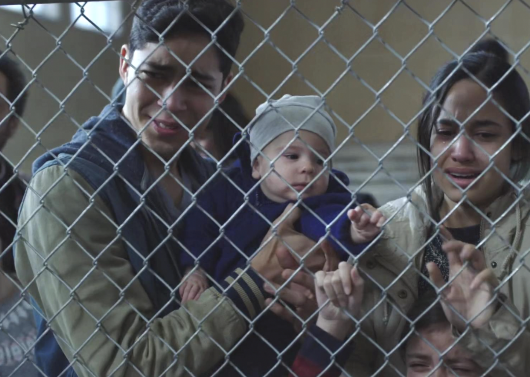 A still showing characters crying behind a fence in Party of Five