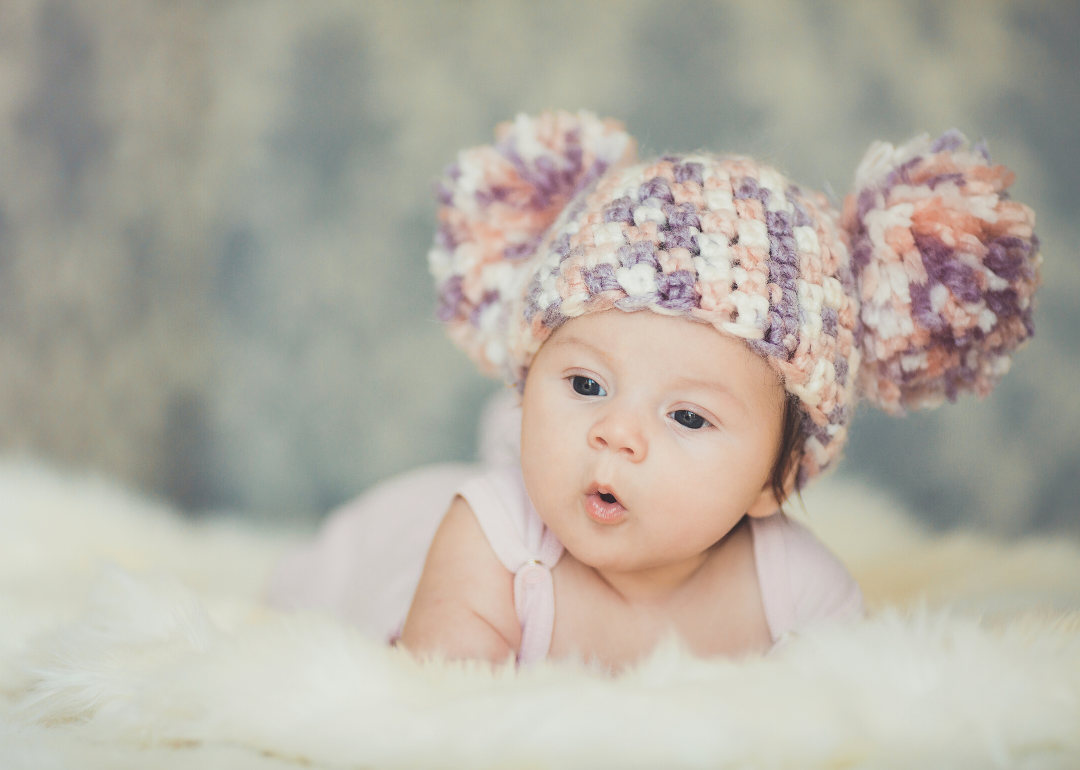 Baby girl with knitted pink cap on.