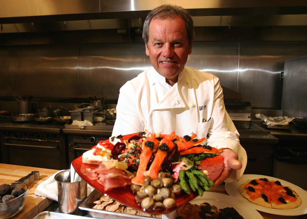 Wolfgang Puck holding a plate of food.