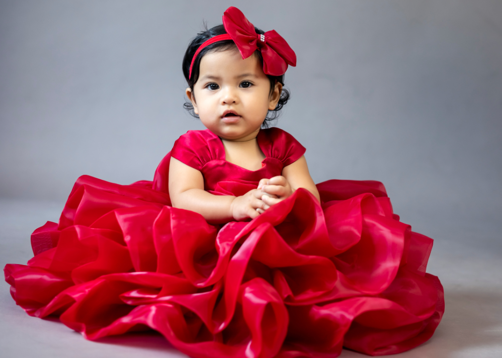Hispanic baby girl posing in a red dress.