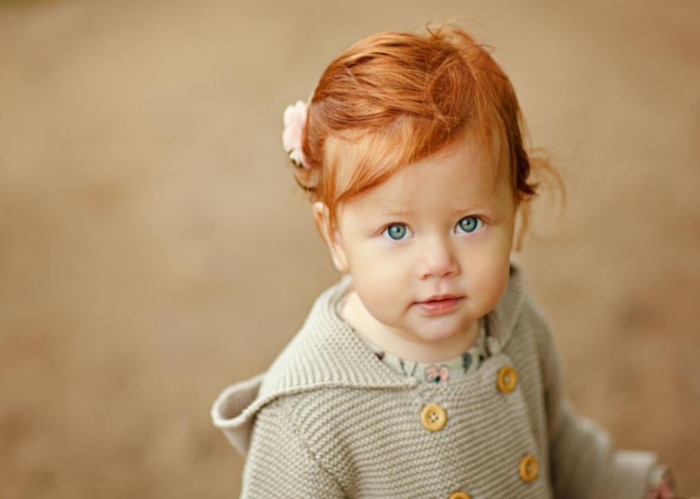 Red-haired baby girl closeup portrait.
