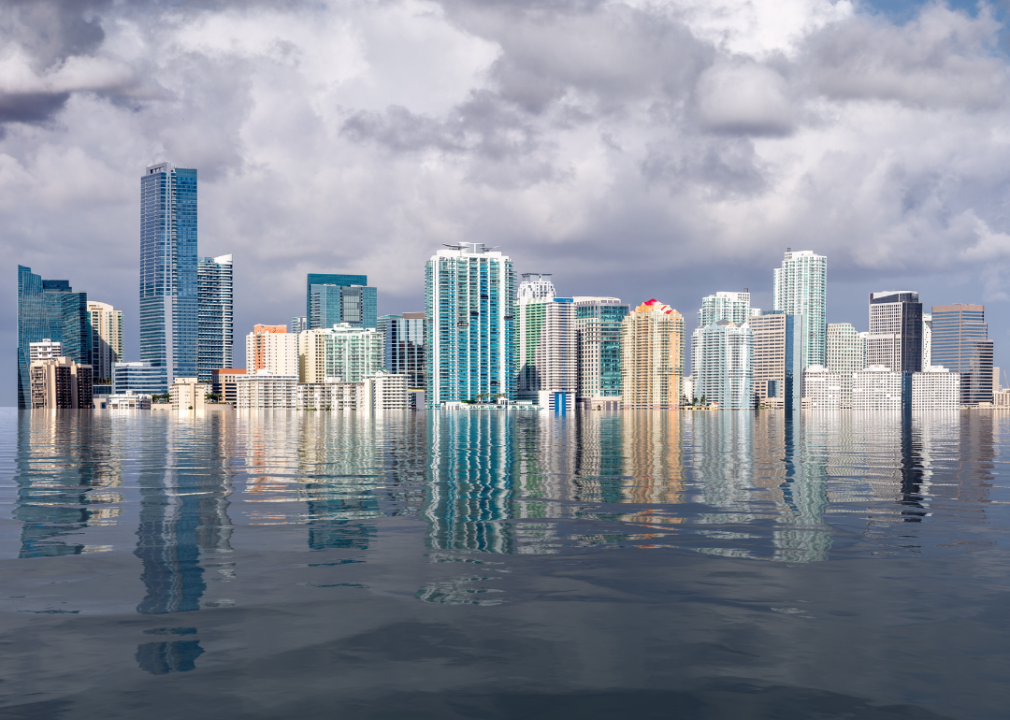 A city skyline flooded by water under a cloudy sky. 