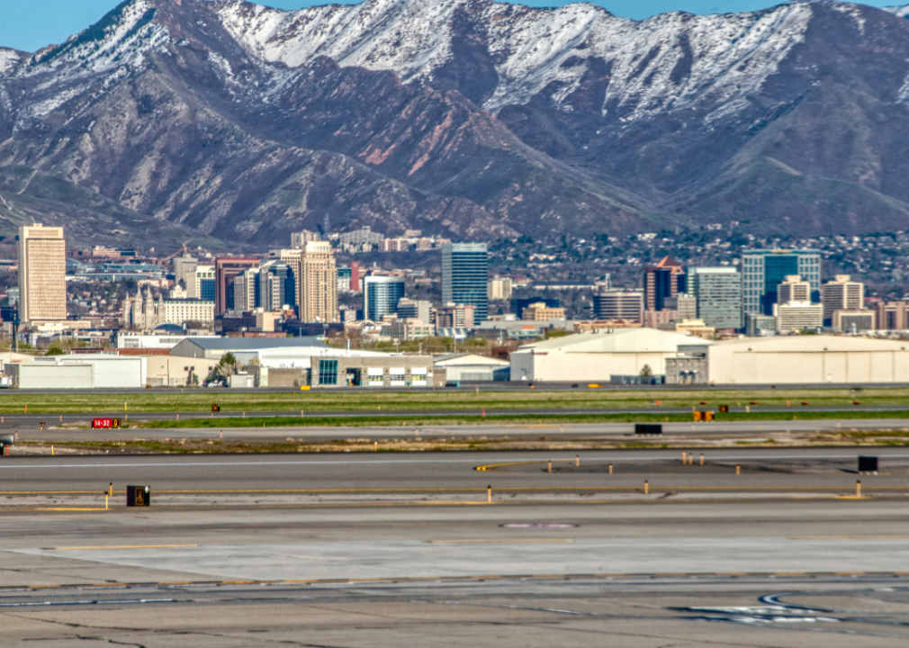 Salt Lake City airport with a view of downtown on the horizon and snowy mountain peaks in the background. 
