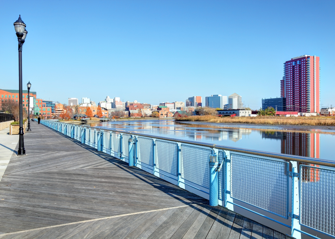 A walking path on the water with Wilmington in the background.