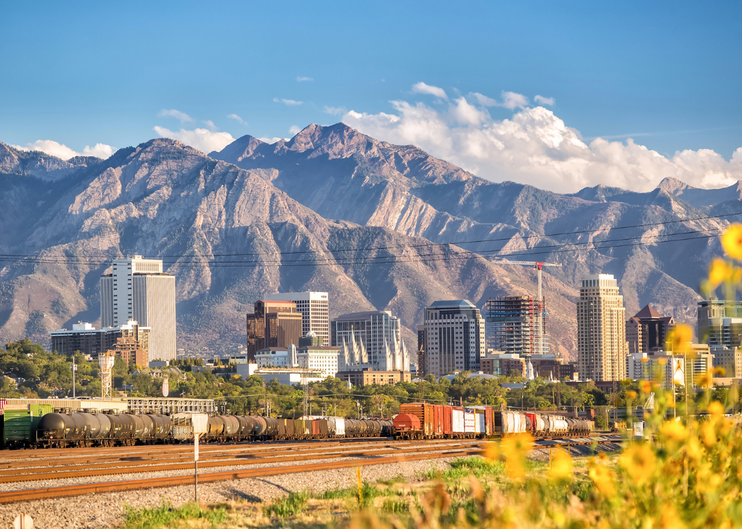 The Salt Lake City skyline with trains in the foreground and mountains in the background.